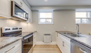 Kitchen with island, white cabinetry, and modern lighting at 320 and 322 Lakeshore Road West