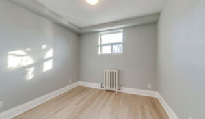 Bedroom with window, radiator heating, and modern flooring at 320 and 322 Lakeshore Road West