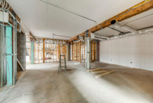 Unfinished medical office interior showing framed walls, open floor area, and mechanical rough-ins