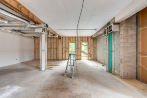 Medical office space under construction with exposed framing, windows, and utility connections