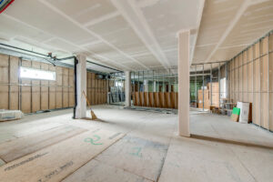 Open-concept medical office space under construction with drywall ceiling and structural columns